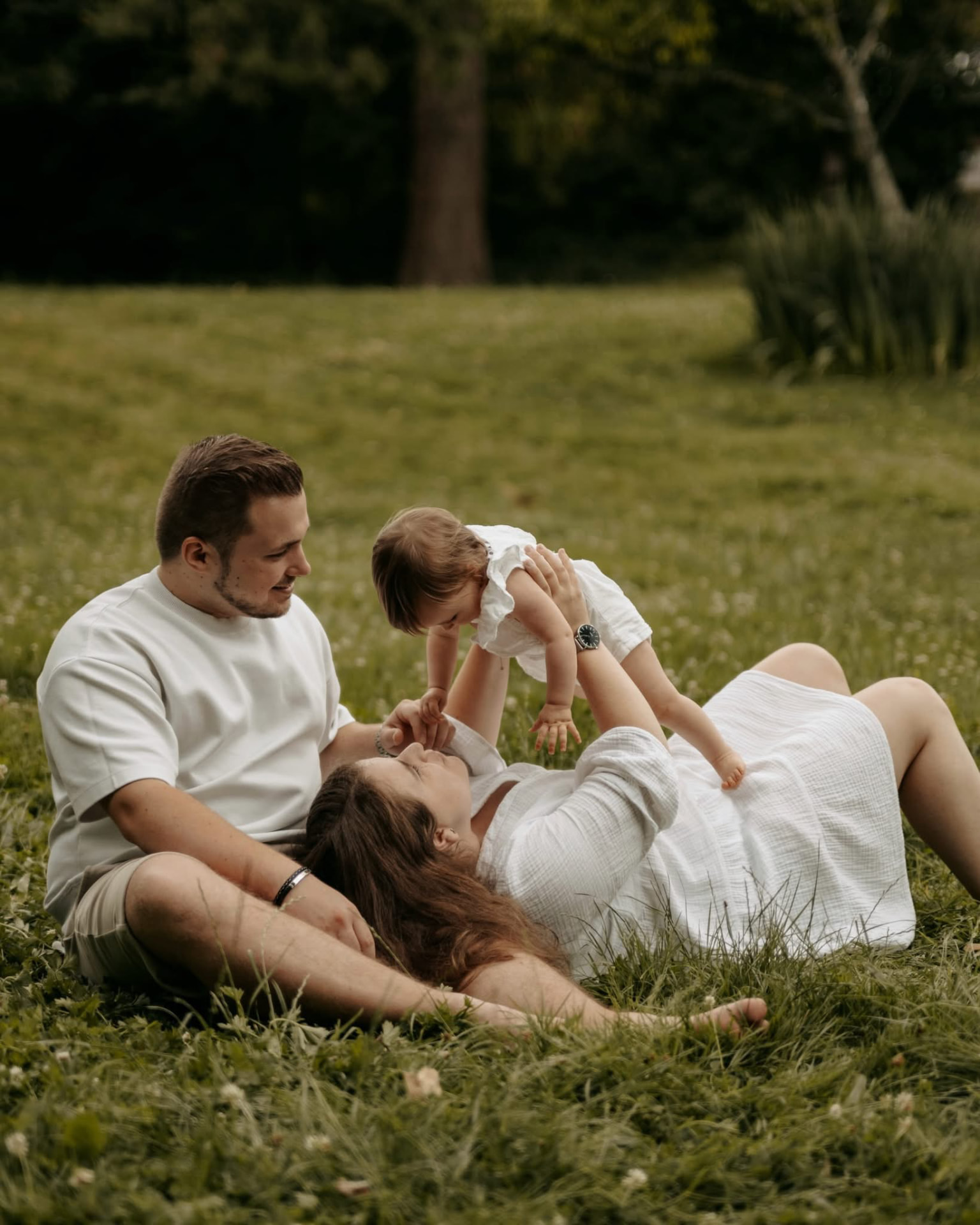 Des parents qui jouent avec leur fille dans l'herbe