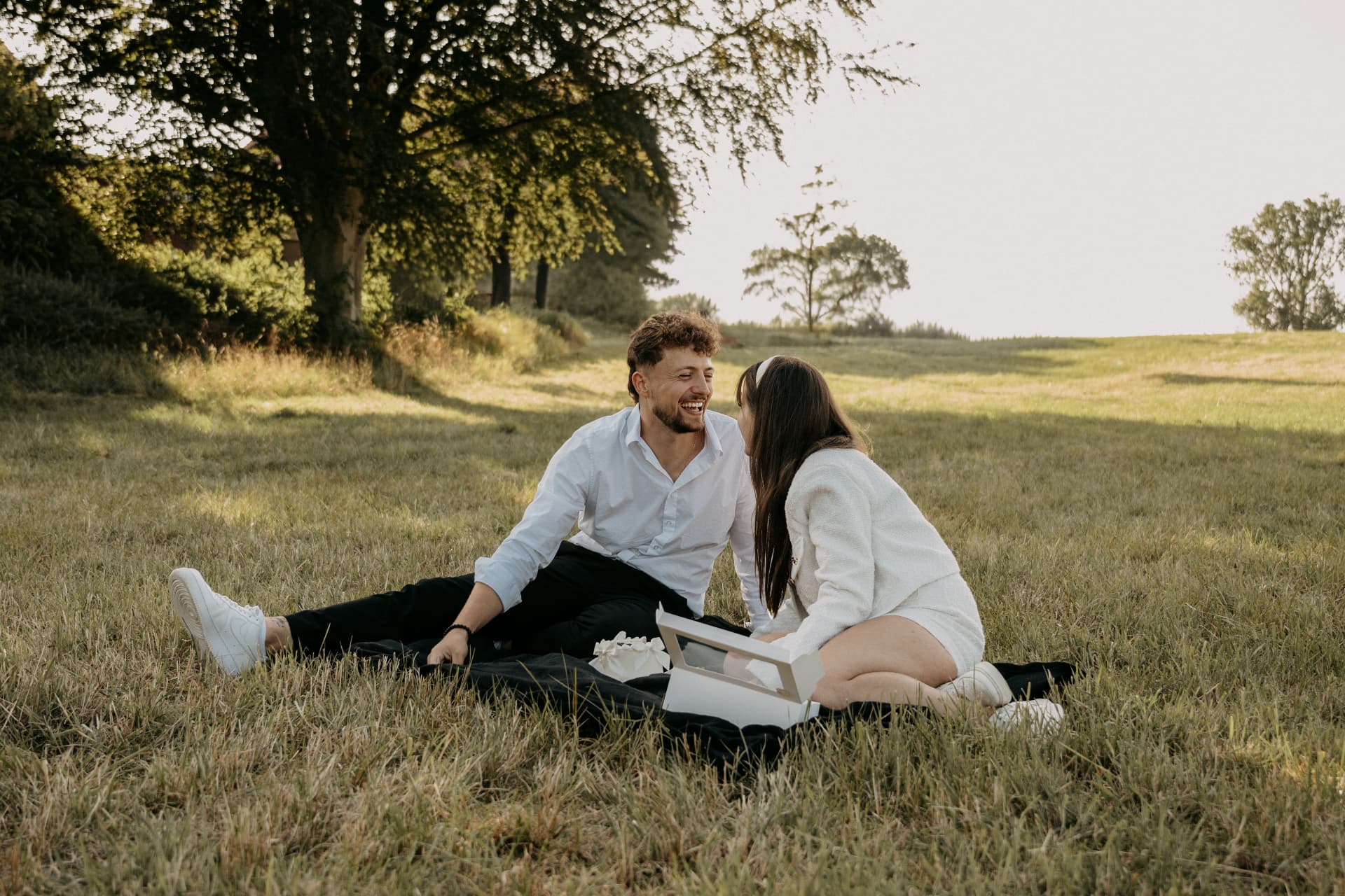 Couple enlacé dans les hautes herbes au coucher du soleil